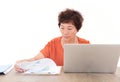 Middle-aged woman sitting in front of a laptop viewing financial documents Royalty Free Stock Photo