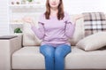 Middle aged woman sitting on the sofa at home background. Copy space and mothers day. Menopause and dieting. Royalty Free Stock Photo