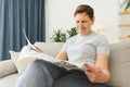 middle aged woman sitting sofa and reading newspapers. Royalty Free Stock Photo