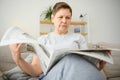 middle aged woman sitting sofa and reading newspapers. Royalty Free Stock Photo