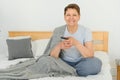 middle-aged woman sitting on the sofa and turning on the TV with a remote control. Royalty Free Stock Photo