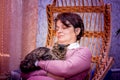 A middle-aged woman is sleeping in a rocking chair with her favorite cat_ Royalty Free Stock Photo