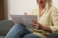 Middle aged woman solving sudoku  on sofa at home, closeup Royalty Free Stock Photo