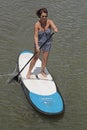 Middle aged woman on stand-up paddle board enjoying herself