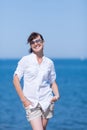 Middle aged woman stands with hands in pockets against sea Royalty Free Stock Photo