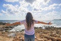 Middle-aged woman stretching her arms breathing fresh air on the Mediterranean coast in front of the sun Royalty Free Stock Photo