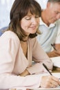 Middle aged woman studying with other students Royalty Free Stock Photo