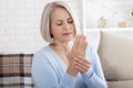 Middle aged woman suffering from pain in hands. Woman massaging her arthritic hand and wrist Royalty Free Stock Photo