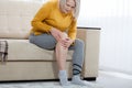 Middle-aged woman suffering from pain in leg at home, closeup. Physical injury concept. Royalty Free Stock Photo