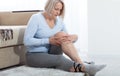 Middle-aged woman suffering from pain in leg at home, closeup. Physical injury concept. Royalty Free Stock Photo