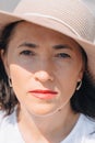 A middle-aged woman in a summer hat looks at the camera. Portrait of a girl. Royalty Free Stock Photo