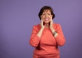 Middle Aged woman with TMJ pain holding her jaw and making a pained expression Royalty Free Stock Photo