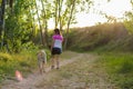 Middle-aged woman walking with her dog on a mountain path Royalty Free Stock Photo