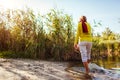 Middle-aged woman walking on river bank on autumn day. Senior lady having fun in the forest enjoying nature Royalty Free Stock Photo