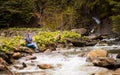 Middle-aged woman walking on river bank on spring day. Senior lady in forest enjoying nature Royalty Free Stock Photo