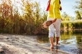 Middle-aged woman walking on river bank on spring day. Senior lady having fun in the forest enjoying nature. Royalty Free Stock Photo