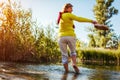 Middle-aged woman walking on river bank on spring day. Senior lady having fun in the forest enjoying nature. Royalty Free Stock Photo