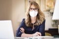 Middle aged woman wearing face mask for prevention while working from home Royalty Free Stock Photo