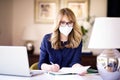 Middle aged woman wearing face mask for prevention while working from home Royalty Free Stock Photo