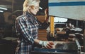 Middle aged woman working with a drill in workshop. Concept of woman in a male-dominated profession, nontraditional gender roles,