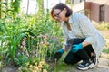 Middle aged woman working in flower bed using gardening tools. Royalty Free Stock Photo