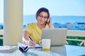 Middle-aged woman working in home office on terrace, talking on phone Royalty Free Stock Photo