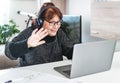 Middle aged woman works remotely and makes a videocall with colleagues - Freelancer has fun while making a call - smart working Royalty Free Stock Photo