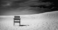 In the middle of the desert, alone with a wooden chair which is empty to give you a rest place Royalty Free Stock Photo