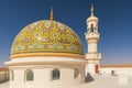 The dome and minaret of a mosque in the desert of Oman