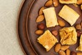 Middle east dessert with honey syrup and chopped nuts in a clay flat round plate. Traditional honey dessert close up