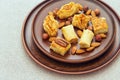 Middle east dessert with honey syrup and chopped nuts in a clay flat round plate. Traditional honey sweets