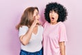 Middle east mother and daughter wearing casual clothes hand on mouth telling secret rumor, whispering malicious talk conversation Royalty Free Stock Photo