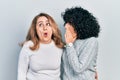 Middle east mother and daughter wearing casual clothes hand on mouth telling secret rumor, whispering malicious talk conversation Royalty Free Stock Photo