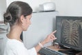 middle east woman doctor looking at monitor with chest bones computer tomography image and pointing at details. female Royalty Free Stock Photo