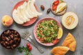 Middle Eastern or Arabic dish tabbouleh salad with pita bread on a gray background. Oriental sweets and fruits,melon, peaches , da Royalty Free Stock Photo