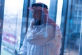 Middle Eastern businessman talking on the phone and looking out the window in his office. Businessman Arabic using mobile phone Royalty Free Stock Photo