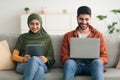 Middle Eastern Couple Using Digital Tablet And Laptop Sitting Indoors Royalty Free Stock Photo