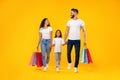 Middle-Eastern Family Shopping Carrying Shopper Bags Walking Over Yellow Background Royalty Free Stock Photo