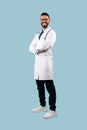 Middle-Eastern Male Doctor Posing Wearing White Uniform Over Blue Background Royalty Free Stock Photo