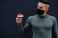 Middle eastern man in gray turtleneck and black face protect mask show Iraq flag isolated background Royalty Free Stock Photo