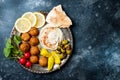 Middle Eastern meze platter with falafel, pita, hummus, pickles, radishes. Mediterranean or greek appetizer party idea. Royalty Free Stock Photo