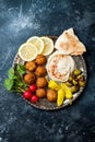 Middle Eastern meze platter with falafel, pita, hummus, pickles, radishes. Mediterranean or greek appetizer party idea. Royalty Free Stock Photo