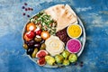 Middle Eastern meze platter with green falafel, pita, sun dried tomatoes, pumpkin, beet hummus, olives, stuffed peppers, tabbouleh Royalty Free Stock Photo