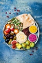 Middle Eastern meze platter with green falafel, pita, sun dried tomatoes, pumpkin, beet hummus, olives, stuffed peppers, tabbouleh Royalty Free Stock Photo