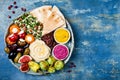 Middle Eastern meze platter with green falafel, pita, sun dried tomatoes, pumpkin, beet hummus, olives, stuffed peppers, tabbouleh Royalty Free Stock Photo