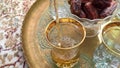 Middle Eastern tea and dates served in a tradtional cups.