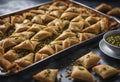 Middle Eastern traditional dessert Baklava or Baklawa. Served in baking tray and topped with delicious crushed pistachio