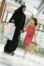 A Middle Eastern woman with a girl shopping