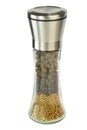 Middle of the frame is a close-up of a pepper mill with different types of peppers lying in layers, on a white background Royalty Free Stock Photo