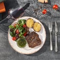 Middle grilled beef steak, with potatoes with cheese and fresh salad, on a wooden table, close-up. glass of red wine Royalty Free Stock Photo